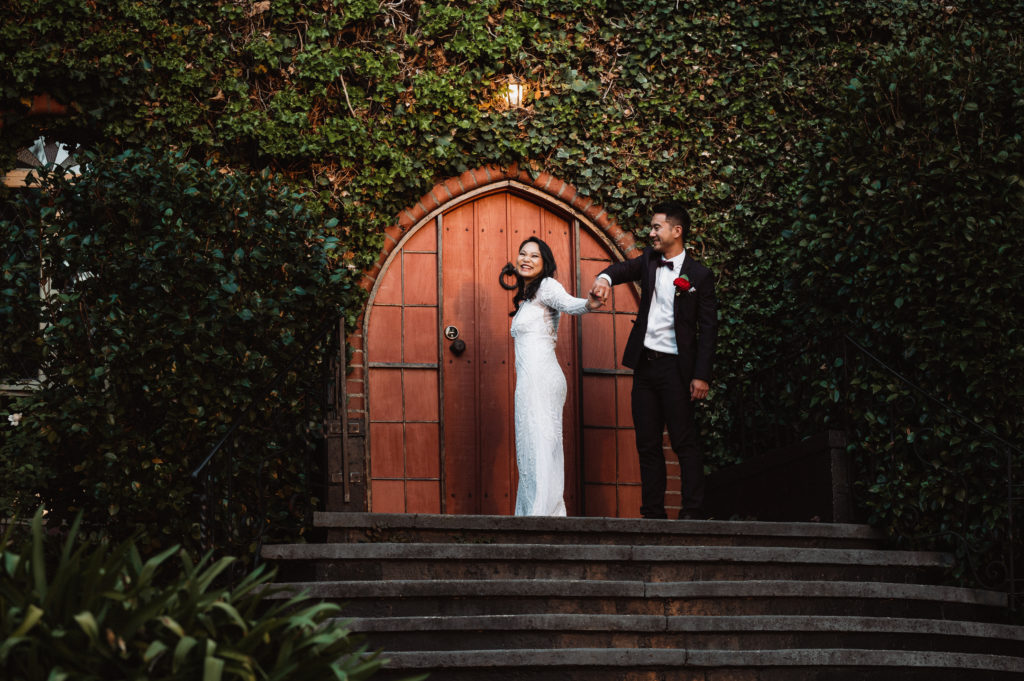 Newlywed couple dance in front
 of castle doors